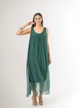 Vestido largo de seda italiana en color verde inglés, con tirantes anchos, escote redondo y diseño holgado con frunces. Cuenta con forro interior de viscosa elastizada.
