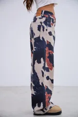 Pantalón de jean de tiro medio-bajo con corte recto y estampado tipo animal print de manchas irregulares en tonos beige, azul oscuro y terracota. Confeccionado en denim rígido sin elastano.