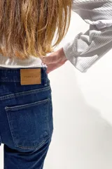 Pantalón de jean azul oscuro, de corte wide leg y tiro medio alto.