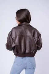 Campera de cuero marrón estilo bomber, con cuello camisero, bolsillos frontales con solapa y puños de tejido elástico.