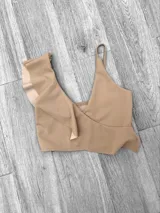 Top de bikini fucsia con un solo tirante y volados en el escote.