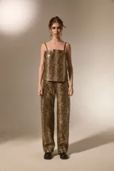 Pantalon de corte recto con diseño de estampado de piel de serpiente, confeccionado en cuero sintético (PU). Presenta bolsillos laterales y cierre frontal con botón.