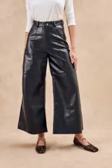Pantalón negro de cuero vegano, corte wide leg y tiro alto.