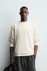 Camiseta sin mangas tipo tank con corte boxy fit, confeccionada en tejido técnico de algodón con elasticidad, cuello redondo y sisas amplias.