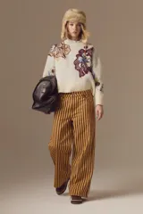 Jean de corte wide leg y tiro medio, con diseño de rayas verticales en tonos amarillo y marrón.