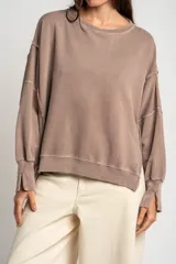 Sweater de algodón peinado con efecto lavado, de corte oversize, cuello redondo y mangas largas con costuras visibles.