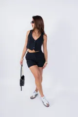 Short de vestir negro con cintura alta, pinzas delanteras y ruedo doblado.