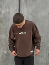 Buzo marrón de algodón con cuello redondo, puños y cintura acanalados. Estampa frontal con el logo de la marca en color blanco.