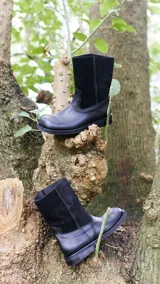 Botas de cuero vacuno color negro, con caña media, suela de caucho y taco bajo.