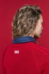Sweater de tejido de punto negro con tramas de ochos en las mangas y laterales, cuello redondo a la base y mangas largas.