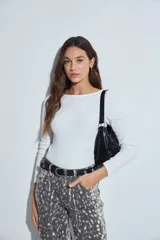 Body de manga larga en color blanco, con cuello redondo y ajuste al cuerpo. Presenta un diseño minimalista y versátil, ideal para usar como prenda base.