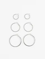 Set de tres pares de aros tipo argolla plateados de diferentes tamaños.