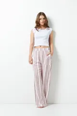 Pantalón de pijama largo con estampado a rayas verticales en tonos rosa y blanco, con bolsillos laterales y cintura elástica.