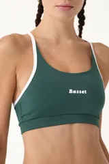 Top deportivo verde con breteles blancos y logo de la marca en el frente.