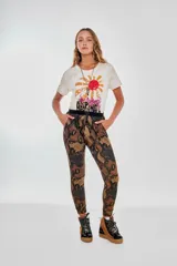 Pantalón tipo babucha con estampado de piel de serpiente en tonos marrones y naranjas, con cintura elástica negra.