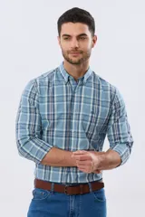 Camisa de manga larga de calce slim, con diseño a cuadros en tonos azul oscuro, verde y blanco. Presenta cuello camisero con botones y bolsillo ojal en el pecho con detalle bordado.
