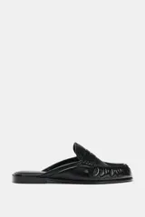 Mocasín destalonado tipo mule negro de cuero suave, con detalle fruncido en la parte delantera y punta redonda.