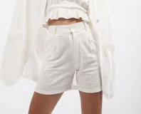 Short blanco de lino con tiro alto, cierre frontal y pinzas.