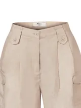 Short de lino orgánico color crema, de tiro alto con pinzas, bolsillos cargo laterales y cierre frontal con botones.