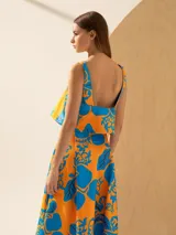 Top con estampado de cerezas en tonos naranja y azul, con breteles finos y detalle de volados en el escote.