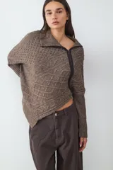 Sweater de punto con diseño de trenzas, cuello polo con cierre frontal asimétrico, manga larga y corte relajado.