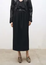 Falda larga de corte recto y tiro medio, confeccionada en una mezcla de lana. Presenta un diseño minimalista con cintura elástica fruncida, bolsillos laterales y una abertura posterior en el bajo.