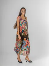 Vestido largo tipo musculosa confeccionado en seda italiana, con diseño de flores abstractas en tonos saturados y nudo regulable en el hombro.