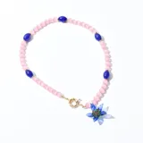 Collar corto de cuentas rosas con cuentas azules y dije de flor azul con centro verde y rojo.
