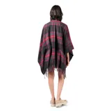 Poncho abierto con diseño de cuadros escoceses en tonos rojo, verde y negro, con terminaciones de flecos en el ruedo.