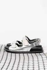 Sandalias plateadas con tiras de velcro ajustables y suela track negra con pespuntes blancos.