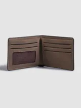 Billetera plegable de diseño clásico en color marrón con acabado tipo nobuk. Presenta costuras a la vista en los bordes y el logo de la marca grabado en la parte frontal. Cuenta con múltiples compartimentos internos para tarjetas, billetes y documentos.