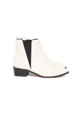 Botas tipo Chelsea de cuero vacuno liso en color off-white, con paneles elásticos laterales en color negro, taco cuadrado bajo y suela de goma.
