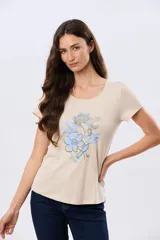 Remera beige de manga corta con cuello redondo, confeccionada en algodón con un diseño delantero que combina estampa floral y detalles bordados.