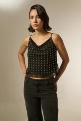 Musculosa negra de poliéster con cuello buche, breteles finos y apliques de tachas metálicas en toda la parte frontal.