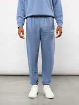 Pantalón jogger de felpa sin frisa color azul, con logo Umbro bordado en la pierna izquierda y puños elásticos en los tobillos.