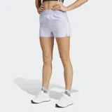 Short deportivo color lila con cintura elástica, cordón ajustable, tecnología AEROREADY, bolsillos laterales con cierre, bolsillo trasero con cierre y detalles reflectivos.