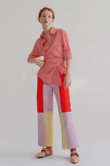 Pantalón de corte recto y tiro alto, confeccionado en tela capitoneada con un diseño de bloques de color en tonos rojo, lila y amarillo. Cuenta con cierre trasero.