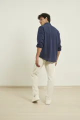 Camisa de manga larga confeccionada en una mezcla de algodón y lino, con cuello abotonado, cierre frontal de botones y un bolsillo en el pecho.