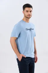 Remera azul marino de manga corta con cuello redondo, confeccionada en mezcla de algodón y poliéster. Presenta un diseño en el frente que combina estampa y bordado con la leyenda "Legacy Brand 1972" en tonos rosado, verde y marrón.