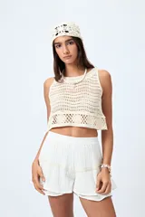 Top color crudo tejido al crochet, sin mangas y con cuello redondo.