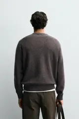 Jersey de punto de algodón con corte relajado, cuello en pico con cierre frontal de botones y manga larga con puños y bajo en rib.