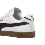 Championes Puma modelo Club Li Era, con diseño de perfil bajo en color negro, franja lateral blanca característica de la marca y suela de goma color caramelo. Presenta detalles en dorado en el logo lateral y la lengüeta.