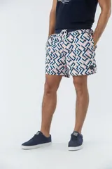 Short de baño azul marino con estampado de hojas de palmera color salmón.