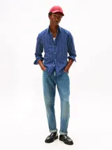 Camisa Tommy Hilfiger de corte regular, confeccionada en tejido Oxford de algodón con textura y diseño de rayas verticales azules y blancas. Cuenta con cuello abotonado, mangas largas con puños abotonados y logo bordado en el pecho.