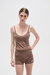 Musculosa deportiva de poliamida, color negro con detalles de ribetes blancos en el cuello y sisas. Presenta un diseño ajustado al cuerpo con escote profundo.