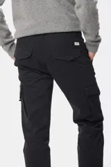 Pantalón cargo azul marino con bolsillos laterales con solapa y cinturón de cuero marrón.