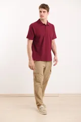 Pantalón de gabardina color beige, de corte recto, con bolsillos laterales tipo cargo y bolsillos traseros con solapa.