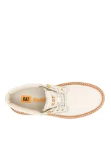Bota tipo chukka de Caterpillar, color beige, con plataforma alta y suela dentada de goma color caramelo. Presenta cordones al tono, ojales metálicos dorados y logo de la marca grabado en el lateral y la lengüeta.