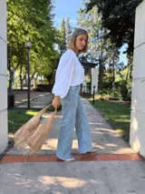 Cartera tipo hobo de cuero color beige con flecos en dos niveles.