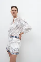 Short de tiro alto color blanco con estampado de palmeras y aves en tonos grises y azules.